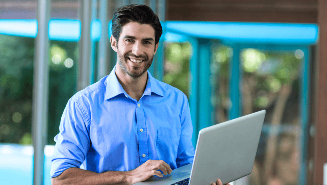 Smiling man with laptop representing expert SEO solutions.